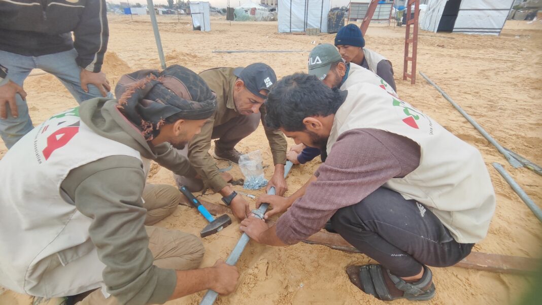 GPAA volunteers assembling water pipe fittings at a displaced persons camp in Gaza