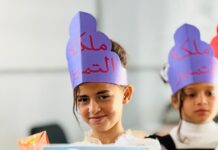 The Gaza Palestinian American Association Supports Al-Furat School and Strengthens Educational Resilience in Gaza A girl wearing a Queen of Excellence crown holding her appreciation certificate from Al-Furat School in Deir al-Balah, Gaza