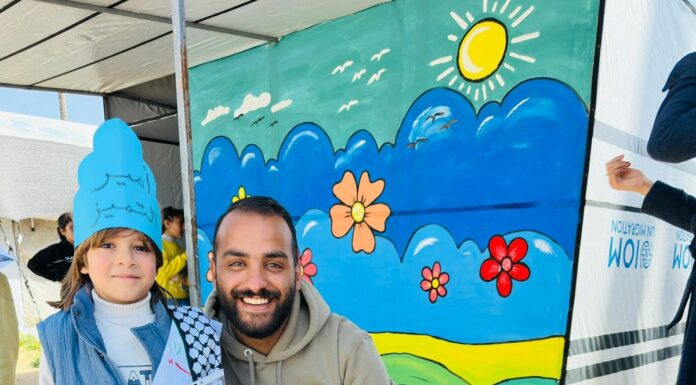 Gaza Palestinian American Association: A humanitarian message to support orphans and build hope GPAA volunteer kneeling with a young orphan child holding an appreciation certificate at a GPAA event in Gaza